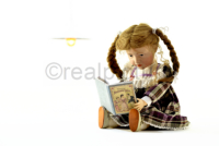 Puppe Elise liest ein Buch ueber Anstandslehre. Doll Elise is reading a book about decency.